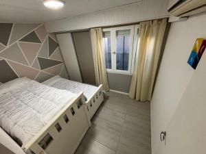 ein kleines Schlafzimmer mit einem Bett und einem Fenster in der Unterkunft Casa necochea in Necochea
