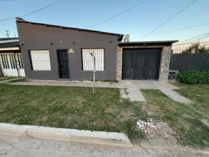 ein Haus mit schwarzen Türen und einem Hof in der Unterkunft Casa necochea in Necochea