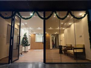 un hall avec un arbre de Noël et une porte en verre dans l'établissement HomeSlice Sarjapur - Balcony Rooms, à Bangalore 26 autres photos
