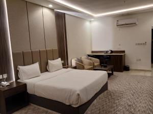 a hotel room with a bed and a desk at سفن روز للشقق المخدومة in Rabba