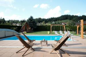 un gruppo di sedie sedute accanto a una piscina di Kamp Nirvana a Šmartno ob Dreti