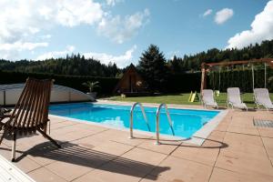 una piscina con due sedie e un'altalena di Kamp Nirvana a Šmartno ob Dreti Altre 12 foto