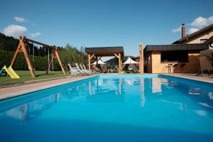 una piscina con parco giochi e una casa di Kamp Nirvana a Šmartno ob Dreti