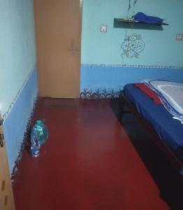 a room with a bottle on the floor next to a bed at Ocean Sparrow Home Stay in Gokarna