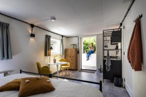 a bedroom with a bed and a woman sitting on the balcony at De Folks in Hoorn