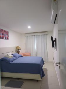 een slaapkamer met een blauw bed en een raam bij Residencial pacific in Cabo Frio +33 foto's