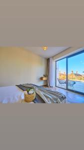 een slaapkamer met een bed en een groot raam bij Dar Charkaoui in Tetouan