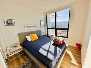 una camera da letto con un letto e una grande finestra di Stunning Lake Views - downtown 2 Bedroom apartment - rooftop lounge a Kelowna