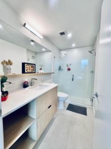 un bagno con lavandino, WC e doccia di Stunning Lake Views - downtown 2 Bedroom apartment - rooftop lounge a Kelowna