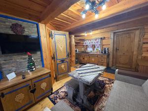 een woonkamer met een tafel in een blokhut bij Zrub Niki in Ždiar