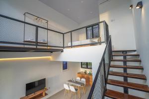 een kamer met een trap en een tafel en stoelen bij Naava Village in Tagalbato