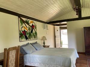 una camera da letto con un letto e un quadro sul muro di Fazenda Vista Soberba a Nova Friburgo