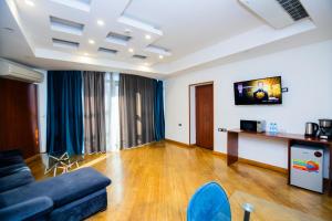 een woonkamer met een blauwe bank en een tafel bij Friendly Hotel Yerevan in Jerevan