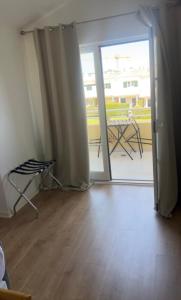 una camera con porta che si apre su un patio con tavolo di Faisões vila a Cascais