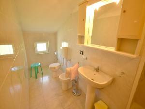ein Badezimmer mit Waschbecken, Toilette und Spiegel in der Unterkunft Spacious home surrounded by nature in Sesta Godano