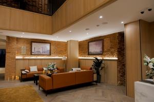 a lobby with couches and tables and a brick wall at Pana Unique Semey in Semey