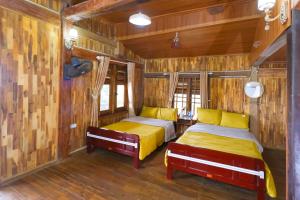 two beds in a room with wooden walls at Cỏ Mây Wonder Homestay in Mộc Châu +77 photos