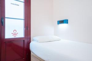 a bed in a room with a window and a door at Malacuna Barcelona in Barcelona