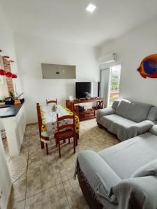 ein Wohnzimmer mit Sofa und Tisch in der Unterkunft Casa de Praia Maresias in São Sebastião