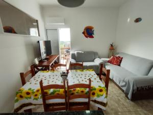 ein Wohnzimmer mit einem Tisch und einem Sofa in der Unterkunft Casa de Praia Maresias in São Sebastião