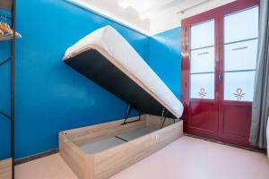 a bed in a room with a blue wall at Malacuna Barcelona in Barcelona
