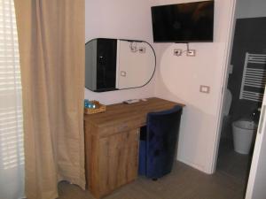 een kamer met een bureau met een televisie aan de muur bij BeB Nido degli Ulivi in Catanzaro +21 foto's