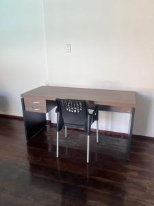 een bureau met een zwarte stoel en een houten bureau bij Pousada e hostel Italia in São Luís