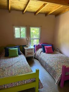 twee bedden in een kamer met ramen bij Jacaranda Mar Azul in Mar Azul