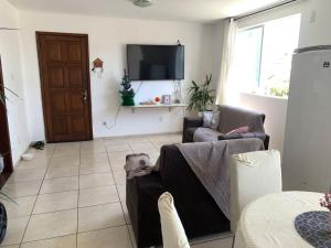 a living room with a couch and a tv at Apto jaraguá lindo in Maceió