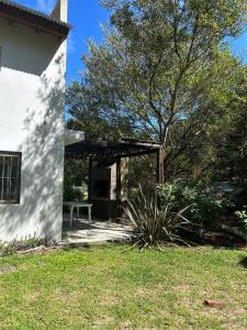 een wit huis met een tafel en een boom bij Jacaranda Mar Azul in Mar Azul