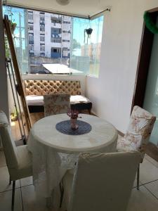 a table and chairs in a room with a window at Apto jaraguá lindo in Maceió