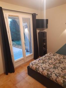 une chambre avec un lit et une porte avec une fenêtre dans l'établissement Sariri, à Brignoles