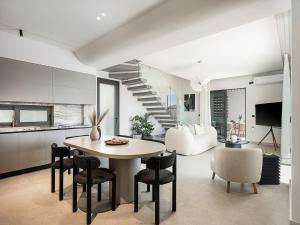 een keuken en woonkamer met een tafel en stoelen bij Sav & Leo Mindful Residences in CHQ