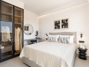 een witte slaapkamer met een bed en een spiegel bij Sav & Leo Mindful Residences in CHQ +23 foto's