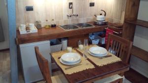 una pequeña cocina con mesa de madera y fregadero en El Pueblo Aparts - Rada Tilly in 
