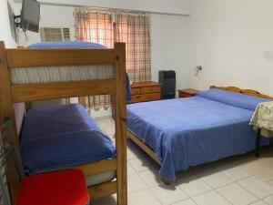 a bedroom with two bunk beds and a red chair at Macaripana in Gualeguaychú +10 photos
