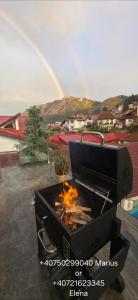 una griglia per barbecue con un arcobaleno sullo sfondo di Roca House a Braşov