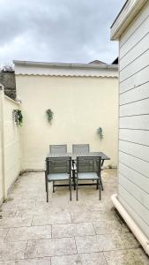 a patio with a table and two chairs at La Maison des Poutres & Lumières - Emile Zola in Croix