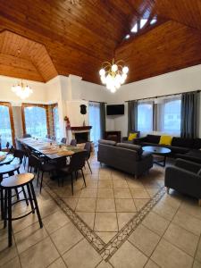 un soggiorno con divani, tavolo e sedie di Erdőparty Vendégház a Tápiószecső