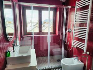 een rode badkamer met een wastafel en een toilet bij Central Guest in Sauze dʼOulx +17 foto's