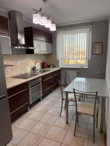 een keuken met een tafel en een tafel met stoelen bij Przytulnie i wszędzie blisko in Siedlce