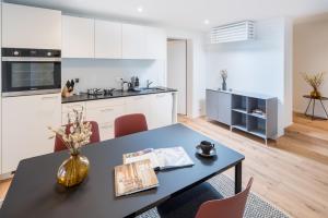 a kitchen and dining room with a table and chairs at Apartments Quellenhöfli in Vitznau +8 photos