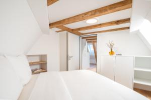 a bedroom with a white bed and white cabinets at Apartments Quellenhöfli in Vitznau