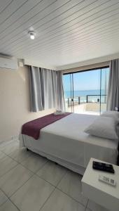 Pousada Sol e Mar Ingleses في فلوريانوبوليس: غرفة نوم مع سرير مطل على المحيط