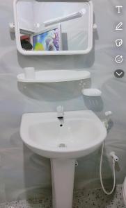 a bathroom with a white toilet and a sink at HindaHaven in Weligama