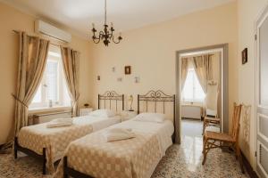 a bedroom with two beds and a chandelier at Ampelaki Blue in Paleokastritsa