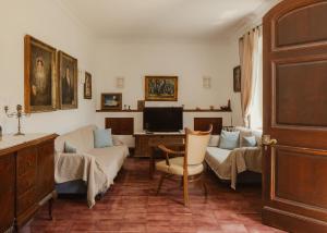 a living room with a couch and a tv at Ampelaki Blue in Paleokastritsa
