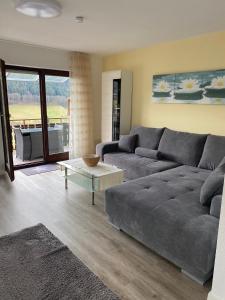 een woonkamer met een grijze bank en een tafel bij Ferienwohnung Inge in Bad Peterstal