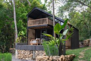 een huis in het bos met een zwart dak bij Mila Villa in Ngingas