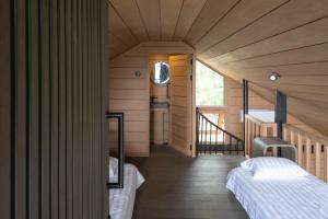 een slaapkamer met 2 bedden in een houten huis bij Mila Villa in Ngingas